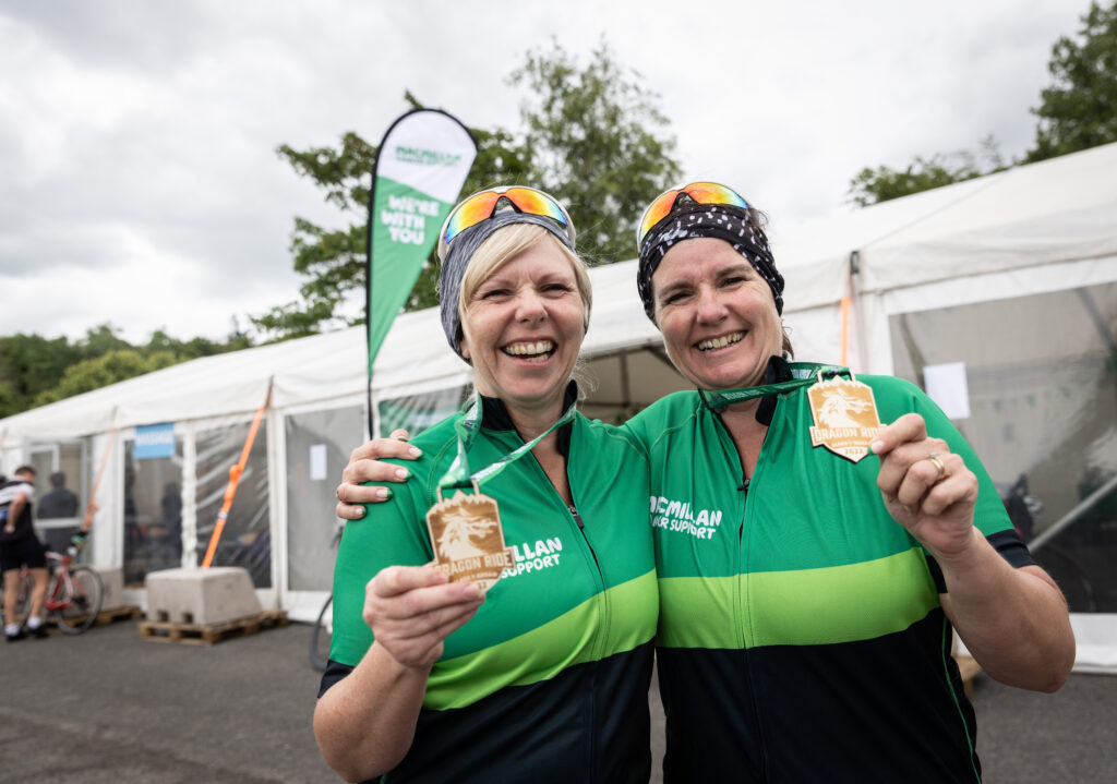 Two Macmillan riders holding their medals